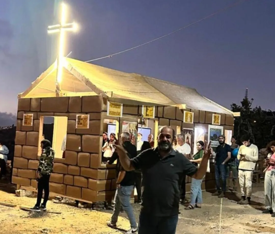 A makeshift chapel with an illuminated cross, built by the community on the Kisiya family's land in Al-Makhrour
